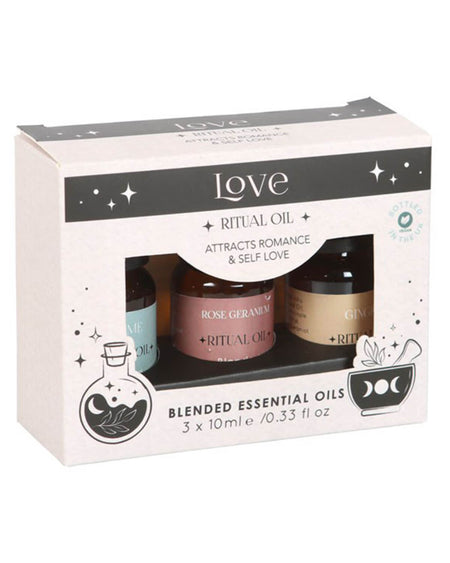 Front-facing boxed set with cut-out windows showing the three essential oil bottles against the Herbal Magick-themed packaging.