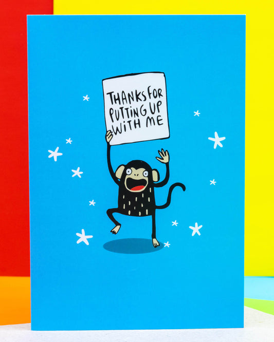 monkey holding a sign that says “Thanks for putting up with me.” Illustrated by Katie Abey, the design is playful and fun, surrounded by white stars. Ideal for showing appreciation with humour. Perfect for gifting from a small UK business that celebrates quirky, alternative styles and retro charm.