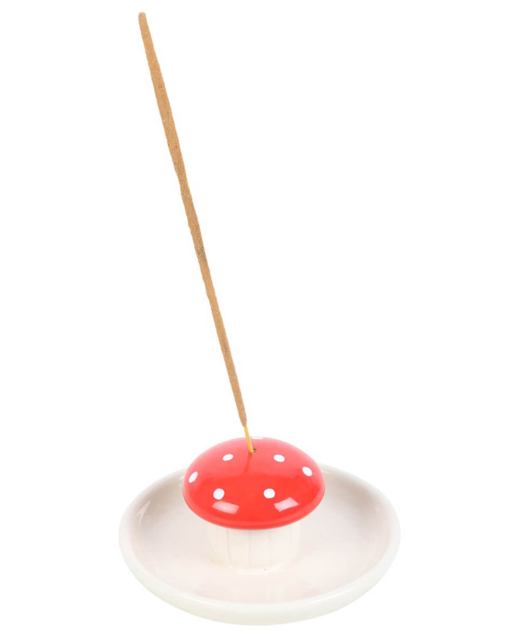 Mushroom incense holder placed on a white surface with green leaves in the background.