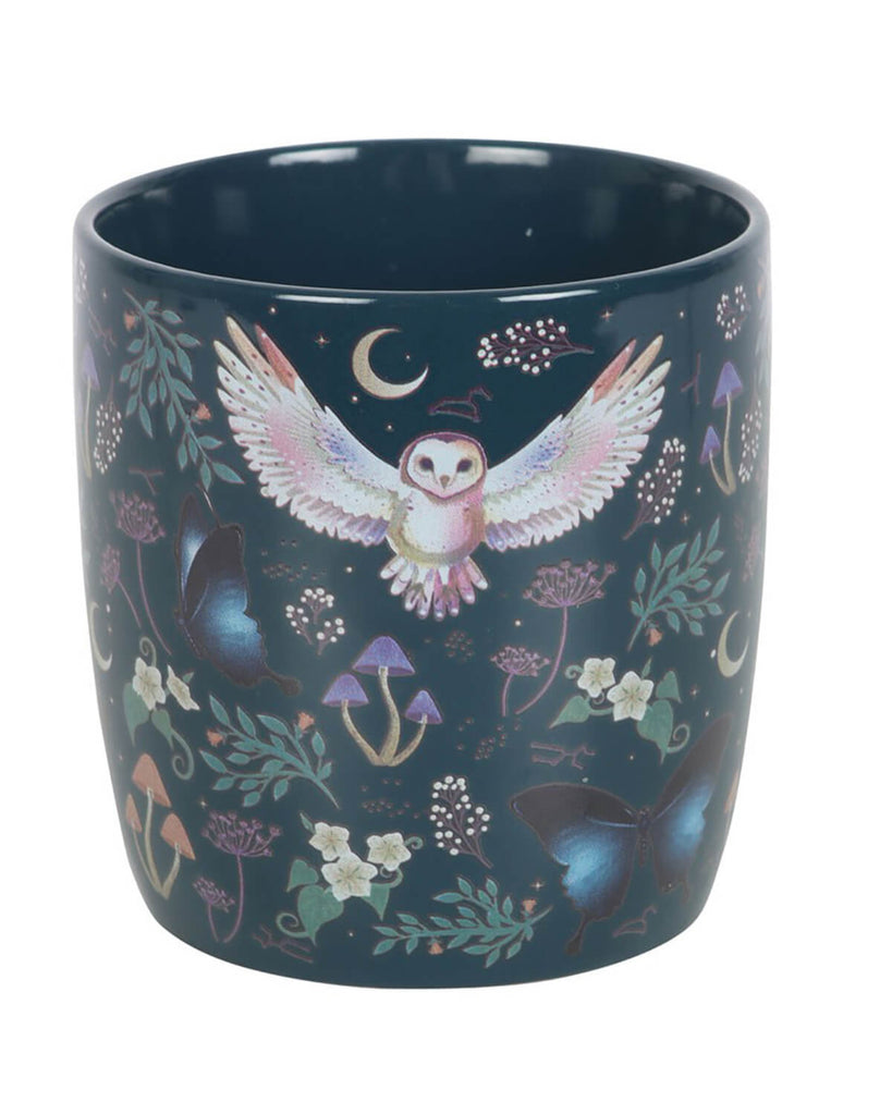 A close-up view of the mug’s artwork, showing a majestic owl with outstretched wings, surrounded by delicate floral patterns, blue butterflies, and tiny stars on a dark background.