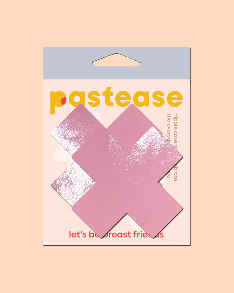 Plus X: Faux Latex Pleather Vinyl Baby Pink Cross Nipple Pasties by Pastease®. Two shiny pastel pink cross shaped nipple covers shown in the pastease packaging on a peach pink background.