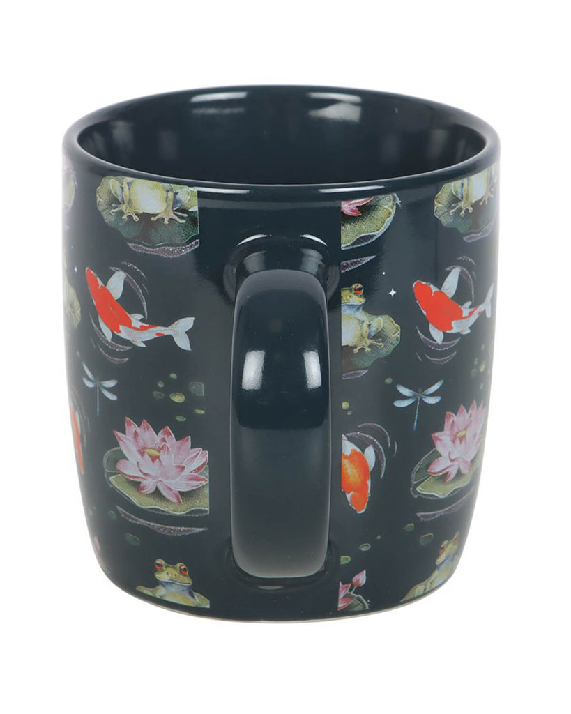Back view of the mug showcasing the handle and continuous pond print with koi fish, frogs, and lily pads against a dark ceramic base.