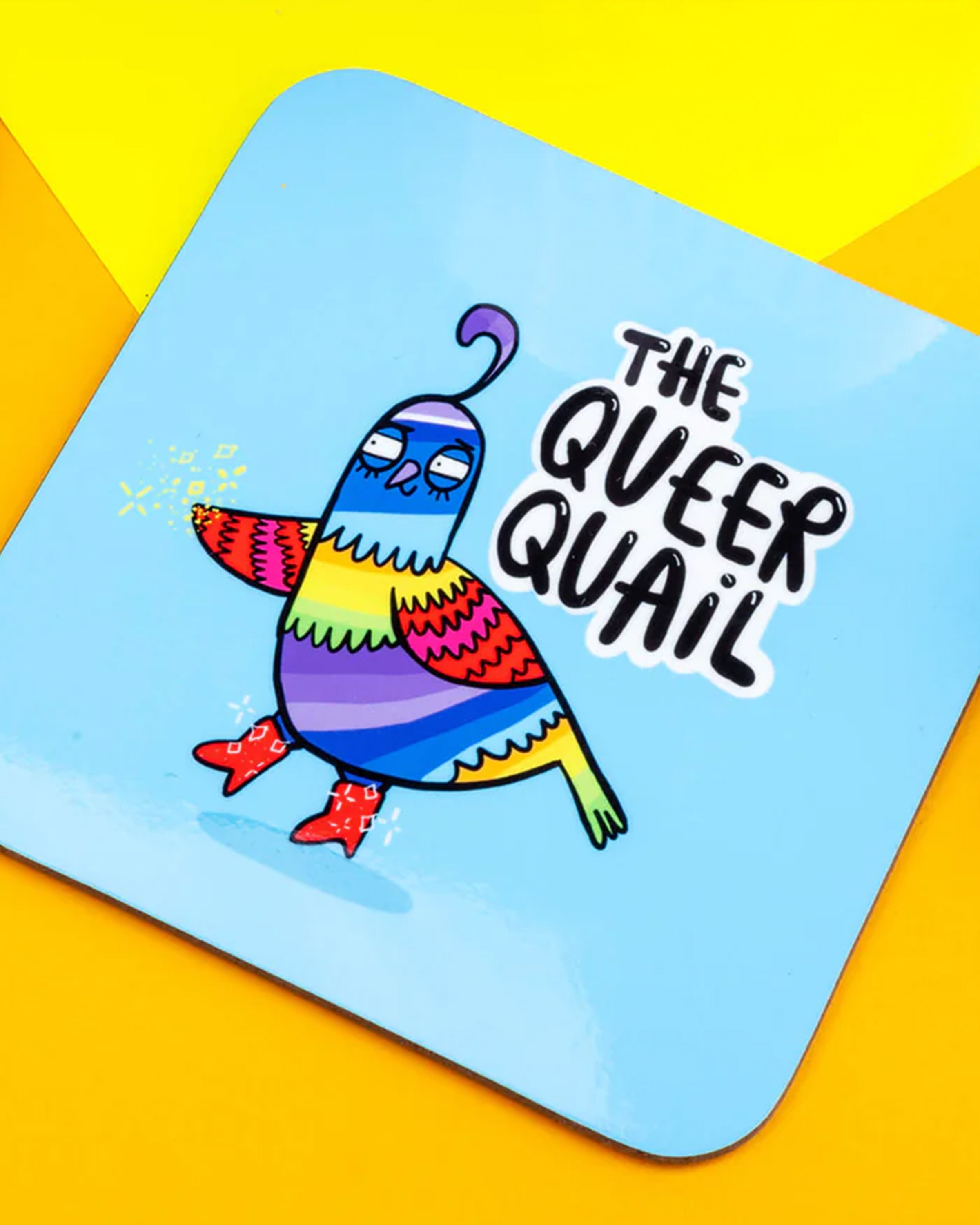 A bright square coaster by Rebel Romance featuring Katie Abey’s “The Queer Quail” design. The quirky quail is illustrated in vibrant rainbow colours with red boots on a light blue background. Fun, bold and alternative homeware from a UK small business celebrating extraordinary style.