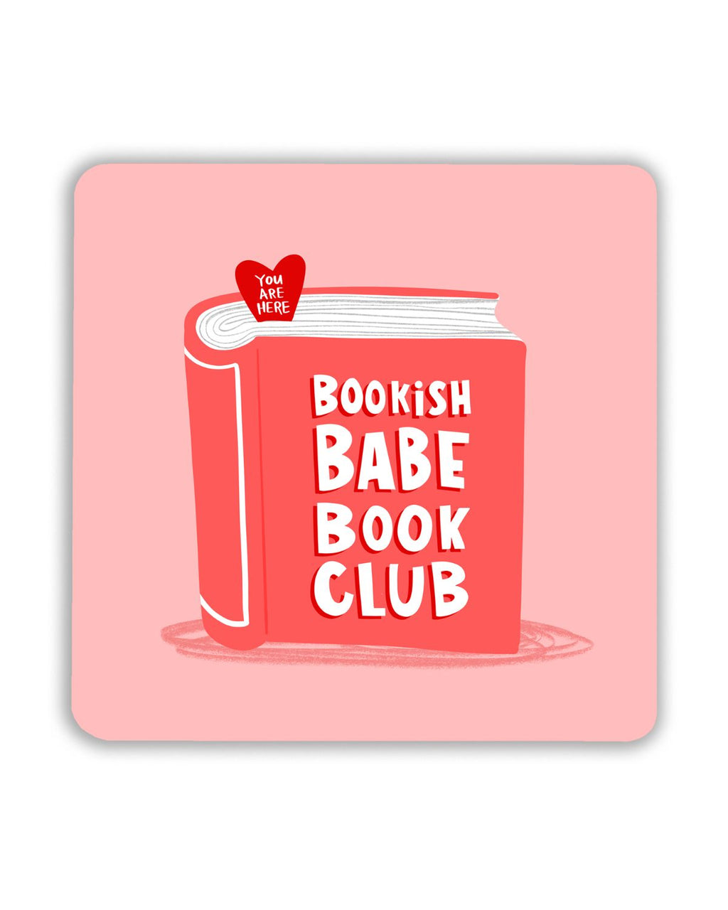 Square pink coaster featuring a red illustrated book with bold white text that reads “Bookish Babe Book Club.” A small red heart-shaped bookmark at the top says “You Are Here.”
