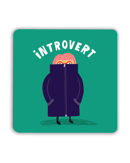 Square teal coaster featuring a cartoon character with pink hair, hiding in an oversized purple coat zipped up to their nose. The word “Introvert” arches above in bold white letters.