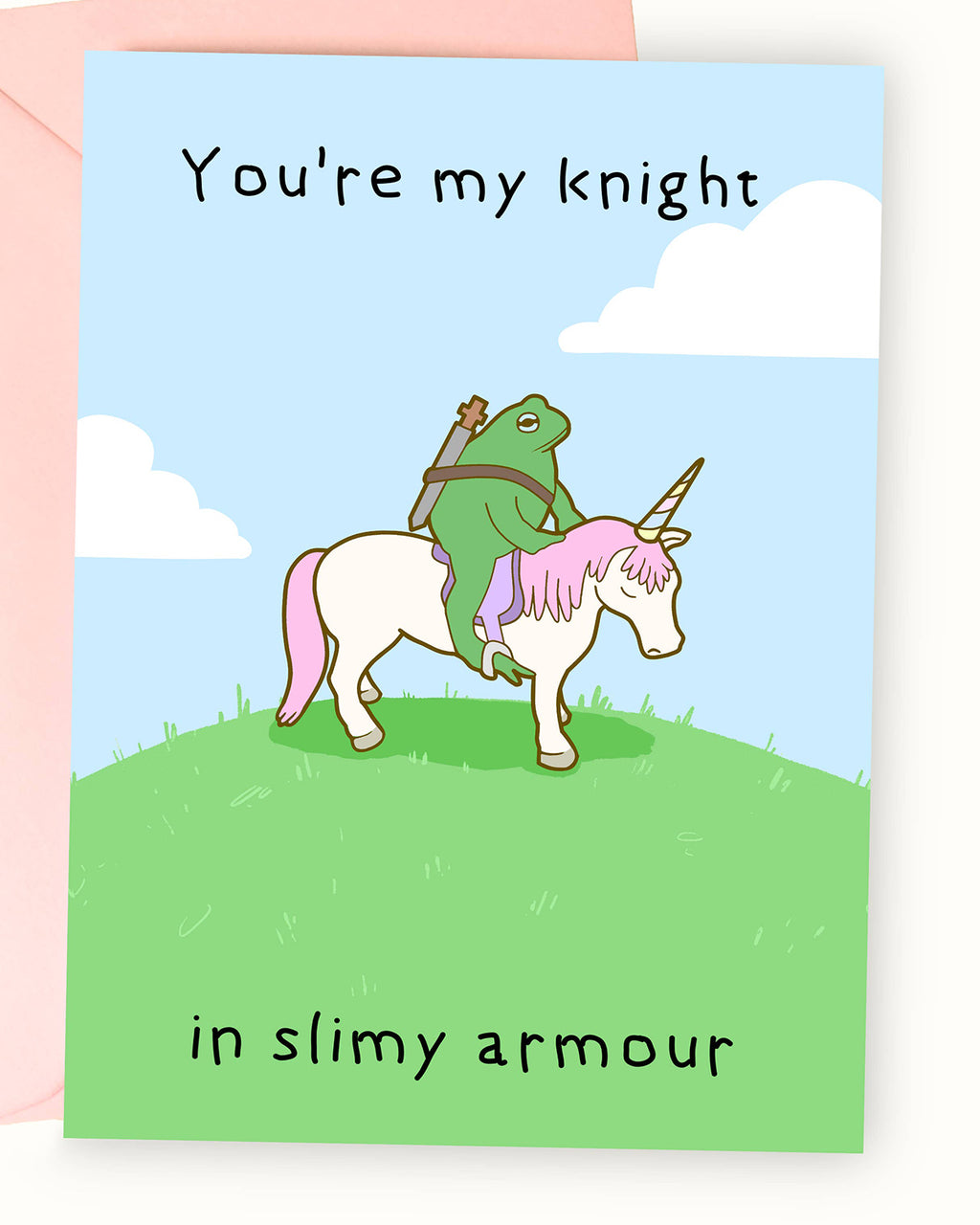 A greeting card featuring a whimsical illustration by Nimbob of a heroic green frog dressed as a knight, riding a white unicorn with pink hair and a golden horn. The frog carries a sword on its back and looks determined. The background is a bright blue sky with fluffy white clouds, and the text above reads ‘You’re my knight’ while the text below reads ‘in slimy armour’ in a playful handwritten font. A fun and charming card, perfect for friendships, anniversaries, or just to make someone smile!