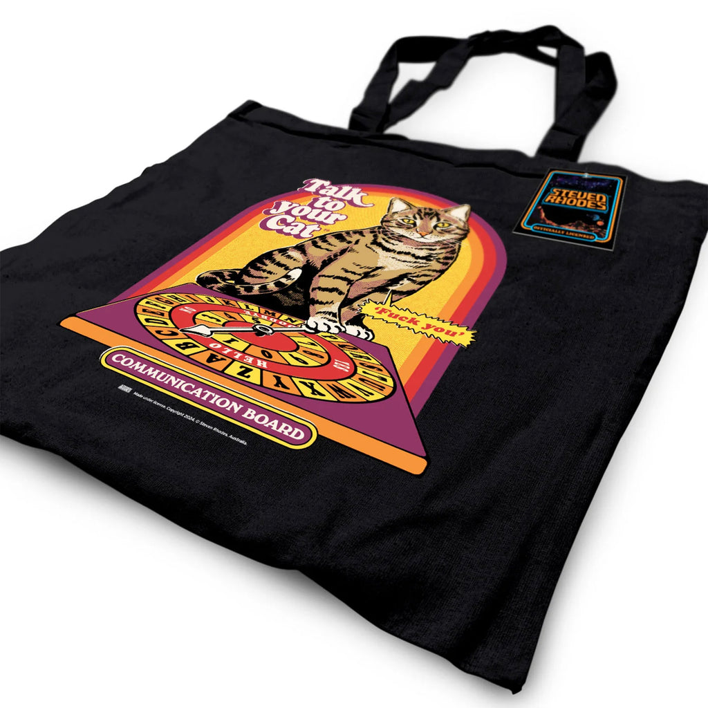 A black tote bag featuring a retro-inspired Steven Rhodes design titled “Talk to Your Cat.” The graphic shows a tabby cat sitting on a colourful communication board, with humorous text and a vintage aesthetic.