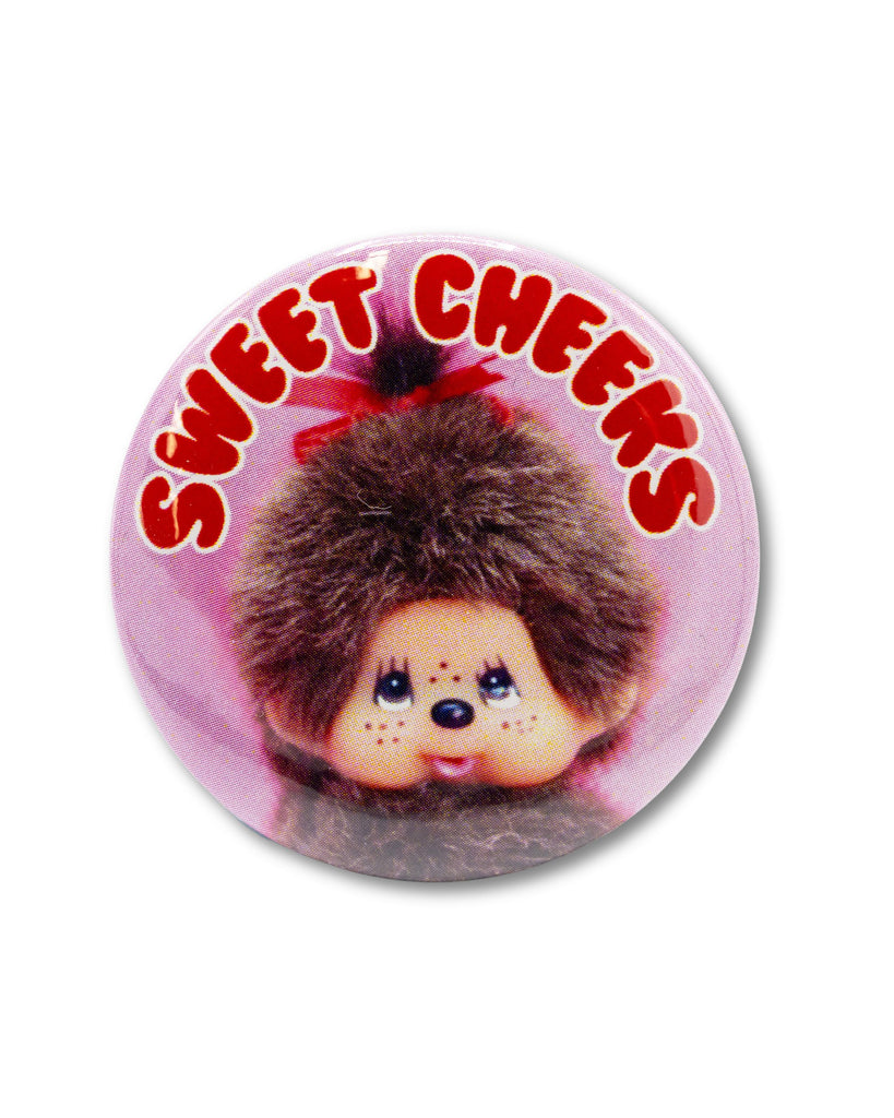 Button badge with a retro monchhichi monkey design and 'Sweet Cheeks' red bubble text on a pink background, an 80s retro design from Bite Your Granny.