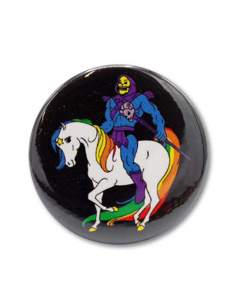 Black button badge with Skelator, a skeleton cartoon character, sat on a rainbow brite unicorn, an 80s retro design from Bite Your Granny.