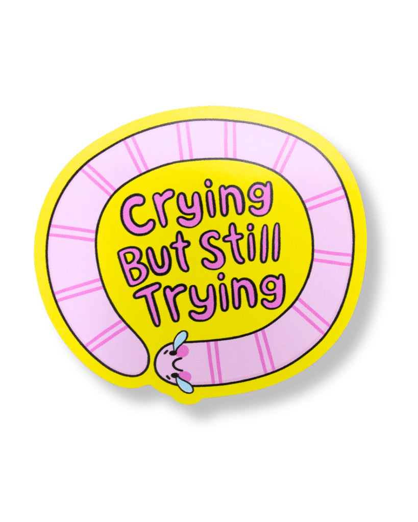 Circular sticker with 'Crying But Still Trying' text on a white background
