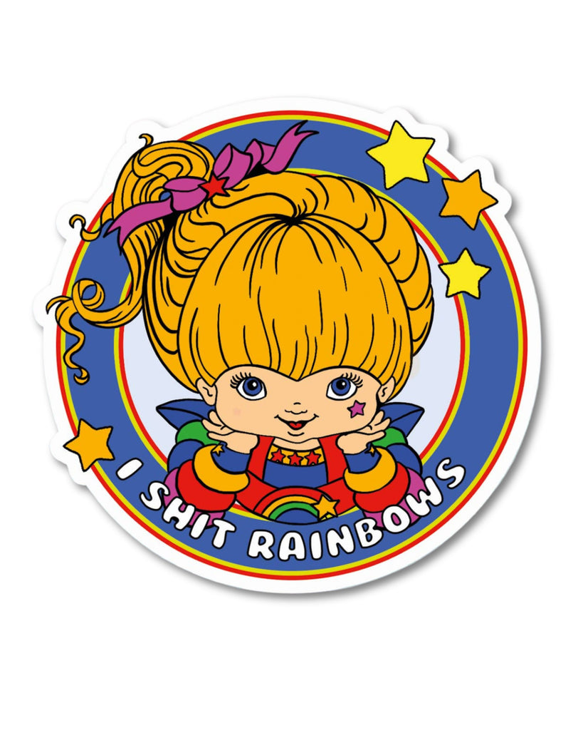 Vinyl sticker featuring a colourful cartoon-style blonde girl with a pink bow, rainbow outfit, and stars around her, designed by Bite Your Granny. The slogan "I Shit Rainbows" is written in bold white text. Sold by Rebel Romance, a UK indie brand celebrating alternative fashion, gifts, and homeware. Durable and full of cheeky charm, perfect for decorating notebooks, laptops or water bottles.