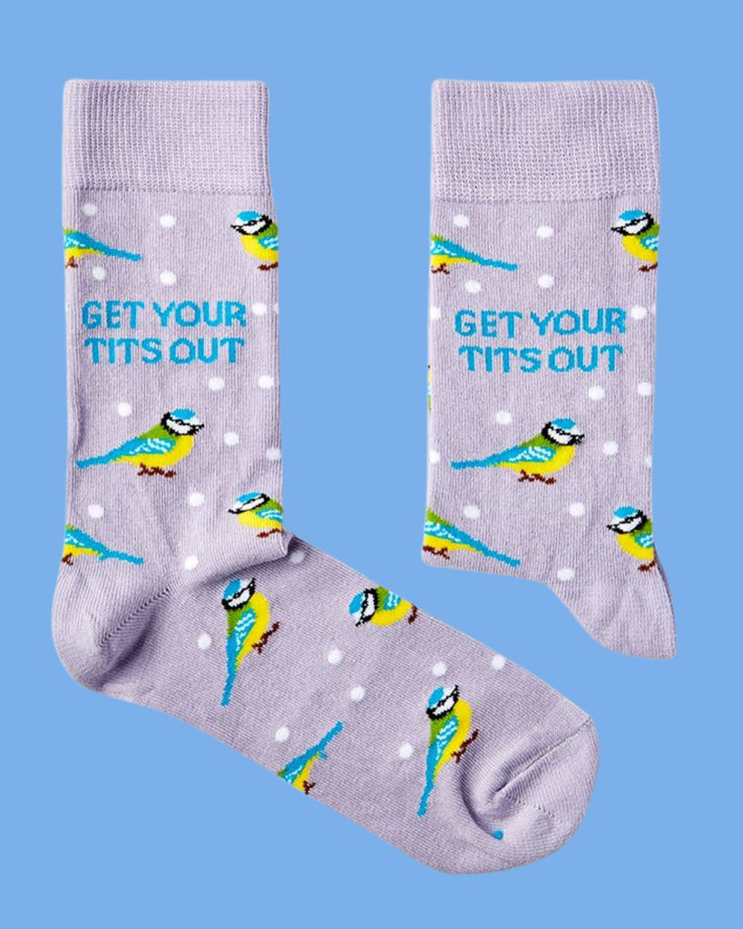 Novelty socks by Urban Eccentric with humorous “Get Your Tits Out” design and bird print, styled on a pastel blue background. Sold by Rebel Romance.