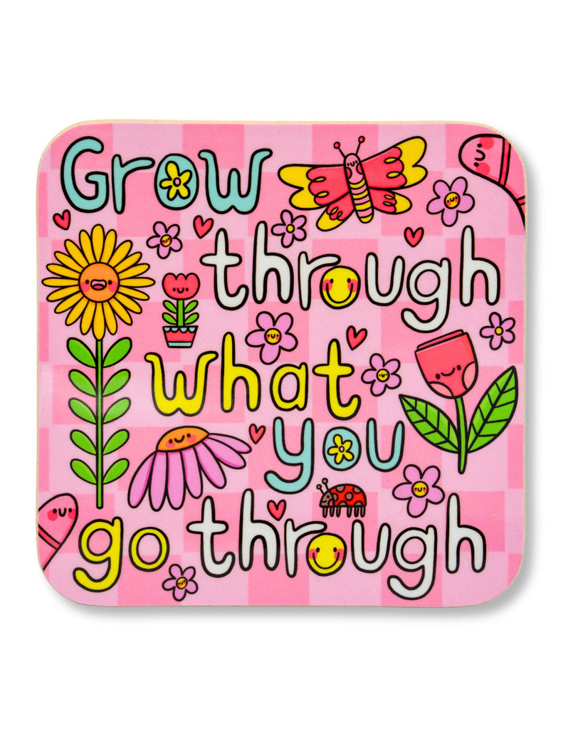 Bright pink square drinks coaster featuring the motivational phrase “Grow through what you go through” in playful, colourful text. The design includes cheerful cartoon flowers, a butterfly, ladybird, hearts, and smiling faces. Illustrated by Kellylou for Rebel Romance, a small UK business that celebrates alternative style and joyful self-expression. Glossy hardboard MDF finish makes it a bold and fun gift or homeware piece.