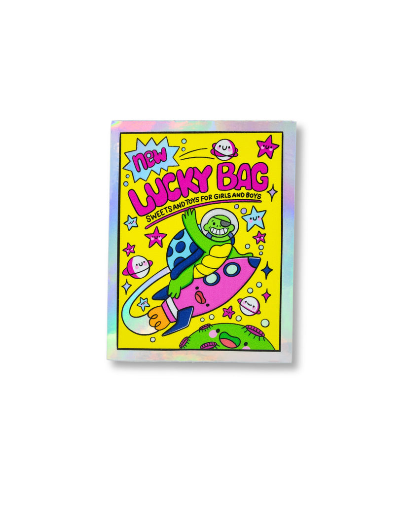 Holographic 90s Lucky Bag Sticker designed by Kellylou for Rebel Romance. Features a nostalgic space-themed design with a rocket-riding turtle, pink stars, and smiley planets. Printed on rainbow holographic waterproof vinyl. Created by an autistic UK illustrator known for quirky, joyful art that adds faces to inanimate things. A fun retro sticker celebrating 90s vibes and alternative style.