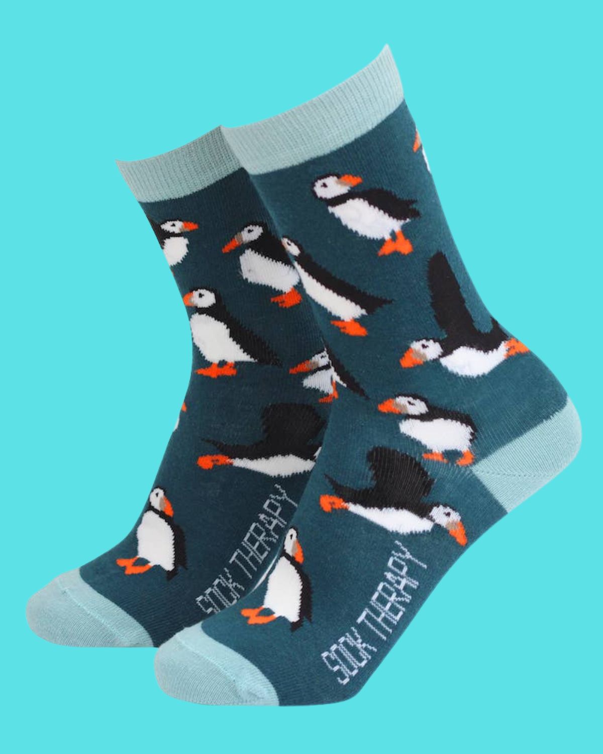 
"Smiling Faces teal bamboo socks featuring adorable puffins in playful poses. Soft and eco-friendly socks with pale blue accents, perfect for animal lovers, available from Rebel Romance.