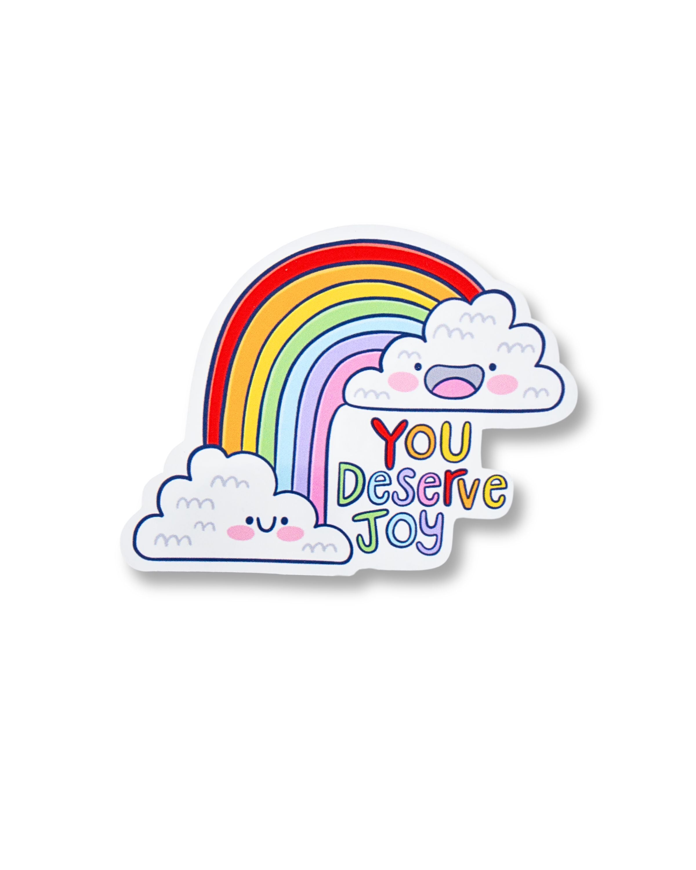 Rebel Romance You Deserve Joy glossy sticker featuring a cheerful rainbow between two smiling clouds with colourful text. A vibrant and uplifting design by Kellylou, perfect for decorating notebooks, laptops, or mirrors. Ideal for spreading positivity and adding a pop of colour to your day. A great gift for millennials who love cute and affirming stationery and alternative art.