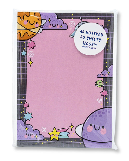 A6 notepad featuring a cute space-themed design illustrated by Kellylou for Rebel Romance. The notepad has a pink centre with a border of smiling planets, stars, clouds, and UFOs on a black grid background. It includes 50 sheets of 120gsm smooth paper, perfect for notes, journalling, or to-do lists. Ideal for lovers of kawaii stationery, space aesthetics, and quirky gifts from a small UK brand that celebrates alternative style.