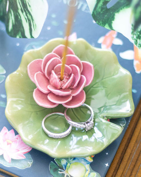 Side view of a green ceramic lily pad incense holder with a pink water lily design. The glossy finish highlights the details of the leaf-like dish, making it a perfect decor piece for holding incense sticks or small trinkets.