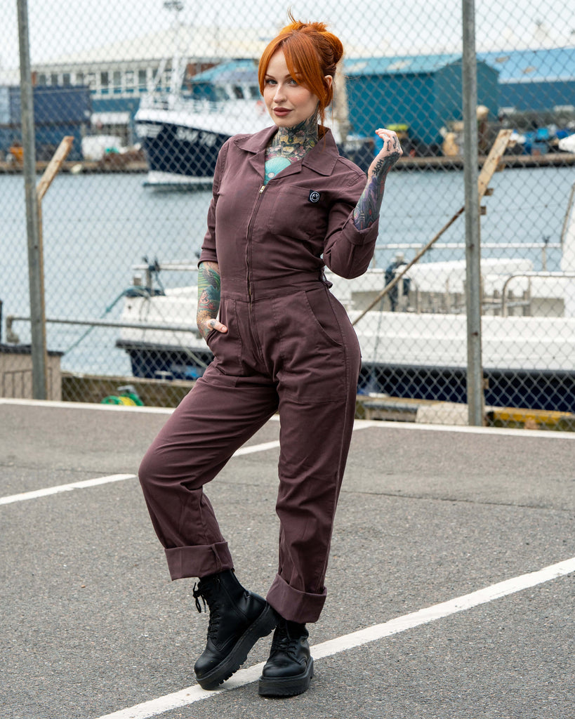 Rebel Romance Plum Mocha Boiler Suit shown on Erin with rolled cuffs and black platform boots. The zip-up jumpsuit features a collar and pockets, styled with tattoos on display for a bold alternative fashion look.