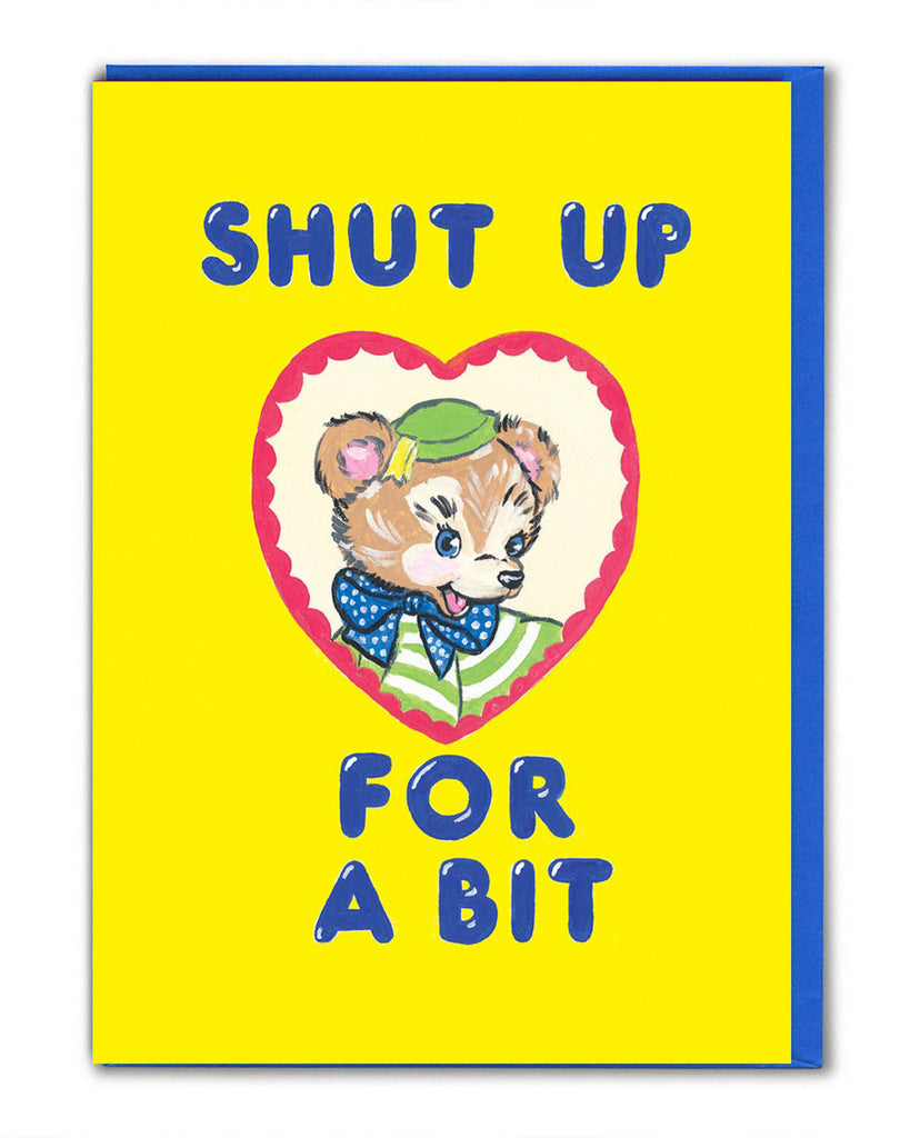 Rebel Romance funny greeting card illustrated by Magda Archer featuring the phrase "Shut Up For A Bit" in bold blue text on a bright yellow background. A retro-style bear character with a green hat and polka dot bow tie sits inside a heart-shaped frame. Perfect quirky card for millennials who love bold, kitschy artwork with a darkly humorous twist.