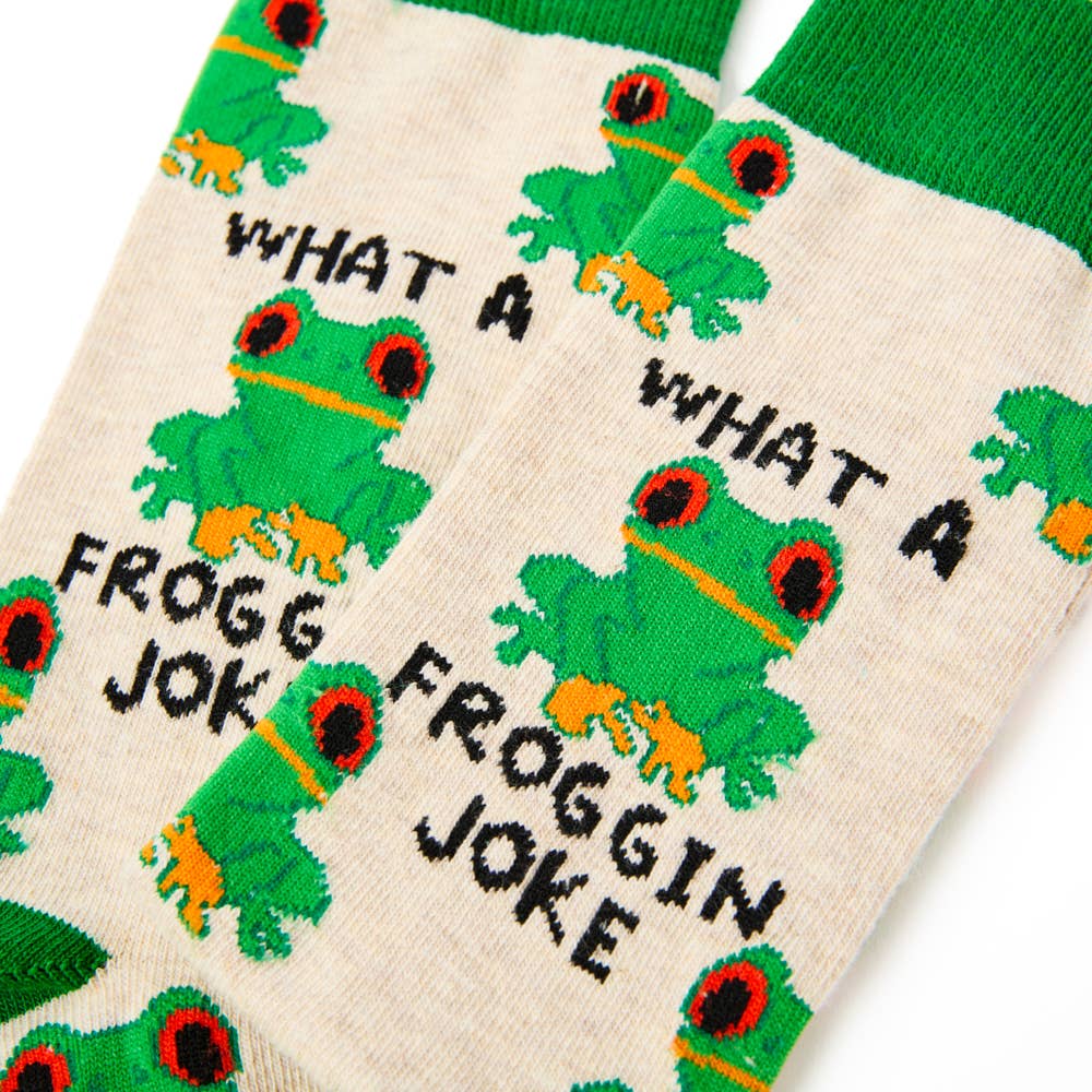 Zoomed-in detail of Urban Eccentric socks with red-eyed frogs and black “What a Froggin’ Joke” text on beige background. Stocked at Rebel Romance.