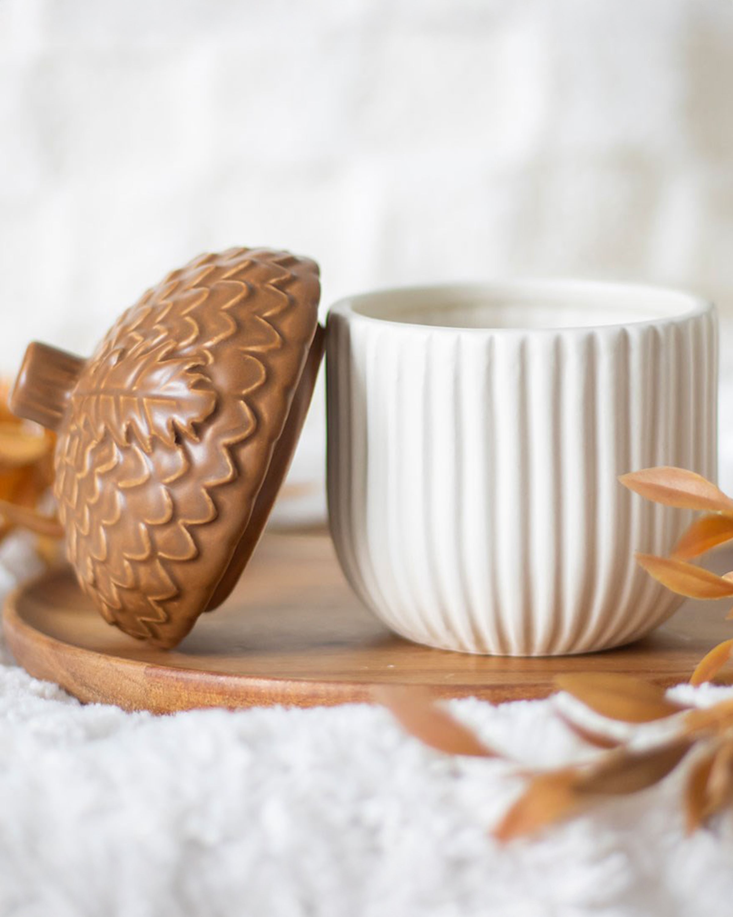 Styled Autumn Acorn Ceramic Storage Jar on a wooden tray with autumn leaves. A cosy, alternative homeware item from Rebel Romance, ideal for snacks, trinkets or seasonal décor.