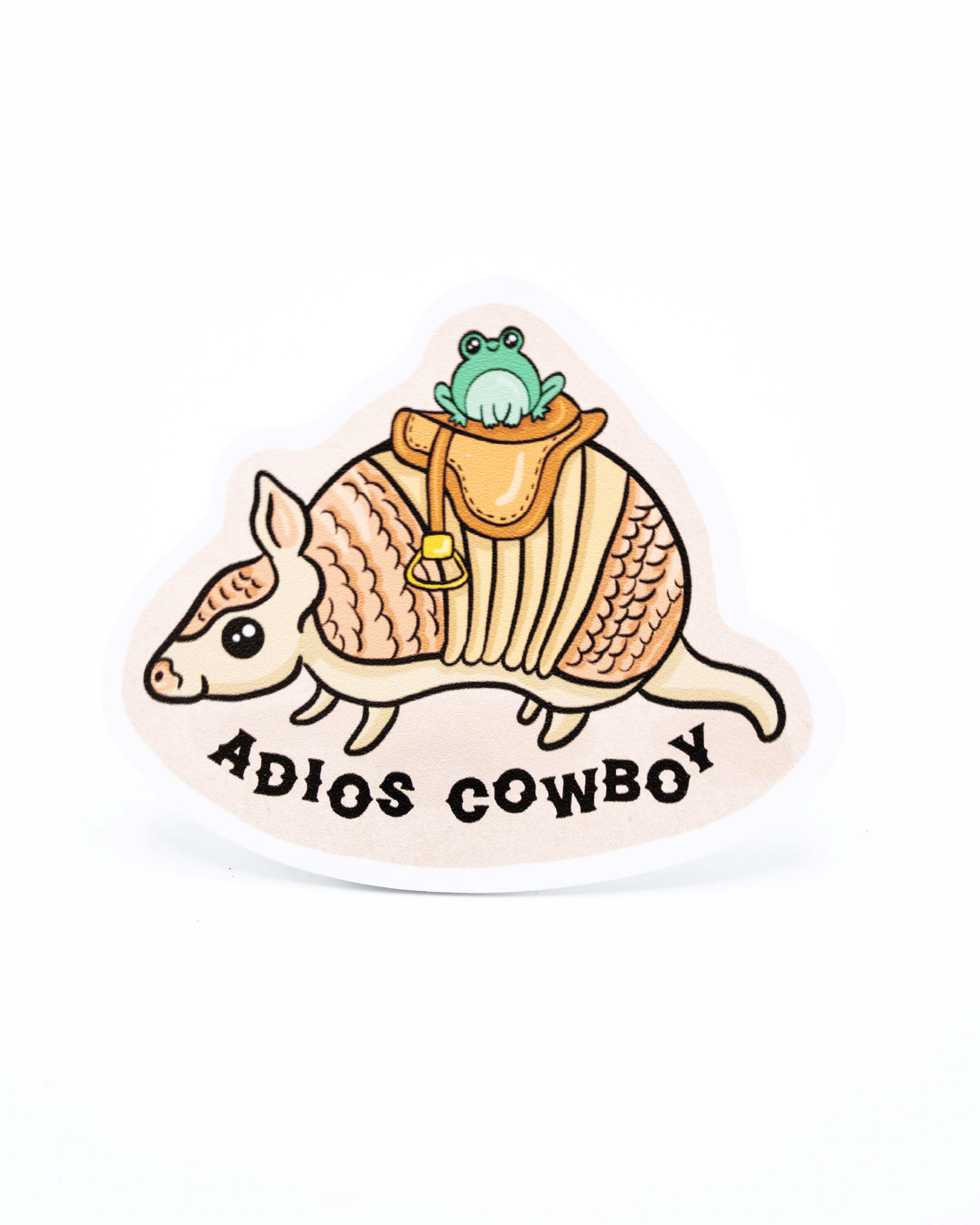 Yasmin cousins vinyl sticker of a cute aardvark wearing a saddle and a smiling kawaii frog with black text underneath reading 'adios cowboy'.