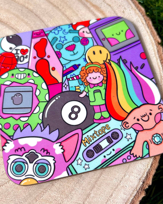Close-up of the Rebel Romance 90’s Nostalgia drinks coaster, designed by Kellylou. The colourful illustration includes a rainbow-haired troll doll, Furby, lava lamp, smiley face, Game Boy, mixtape, 8-ball, and other iconic 90s characters and toys. The coaster has a glossy finish and is photographed on a wooden surface.