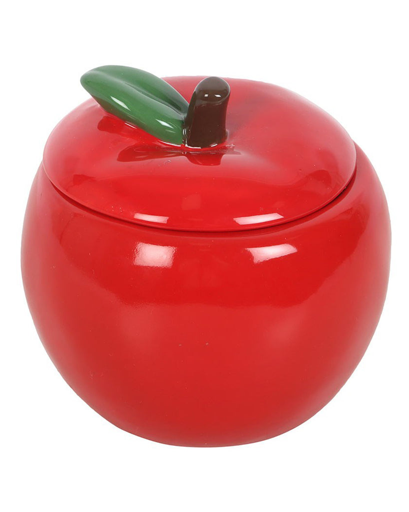 Side angle of the apple-shaped candle jar with its lid on, showing the detailed sculpting of the green leaf and brown stem at the top centre.