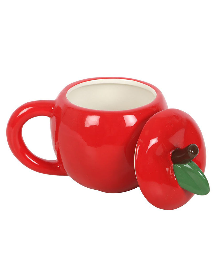 Apple-shaped ceramic mug with the lid removed, showing the inside of the mug next to the red lid with green leaf detail.
