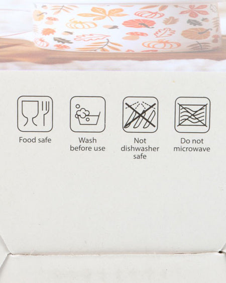 A close-up of the Autumn Leaves and Pumpkins Mug’s packaging, highlighting the care instructions. The icons indicate that the mug is food-safe, should be washed before use, and is not suitable for microwaves or dishwashers.
