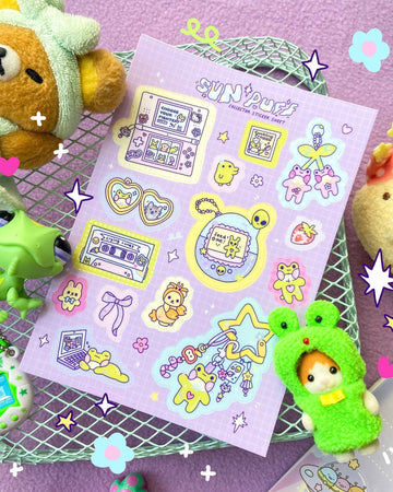 Pastel purple A6 sticker sheet from Rebel Romance featuring nostalgic 90s-style trinkets designed by Sun Puff Studios. Includes cute Tamagotchi, heart cassette tape, game console, duck plushie, laptop, stars, and whimsical accessories. Printed on glossy vinyl for weatherproof durability. A dreamy sticker set for journalling, scrapbooking, and decorating with Y2K vibes. Ideal for fans of kawaii, retro, and indie stationery aesthetics.