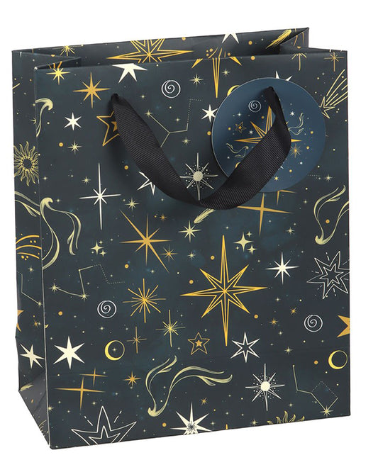 Medium Starry Night gift bag with black ribbon handles, decorated with gold stars and constellations on a navy background, photographed upright on a white surface.