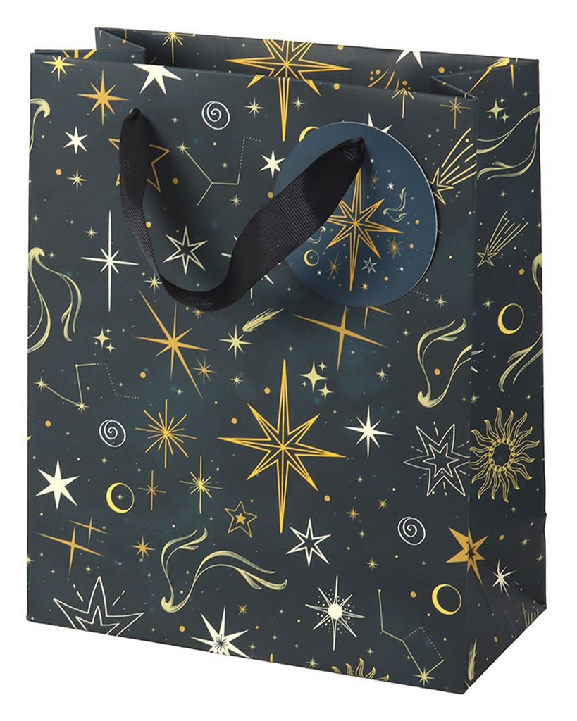 Medium Starry Night gift bag with black ribbon handles, decorated with gold stars and constellations on a navy background, photographed upright on a white surface.