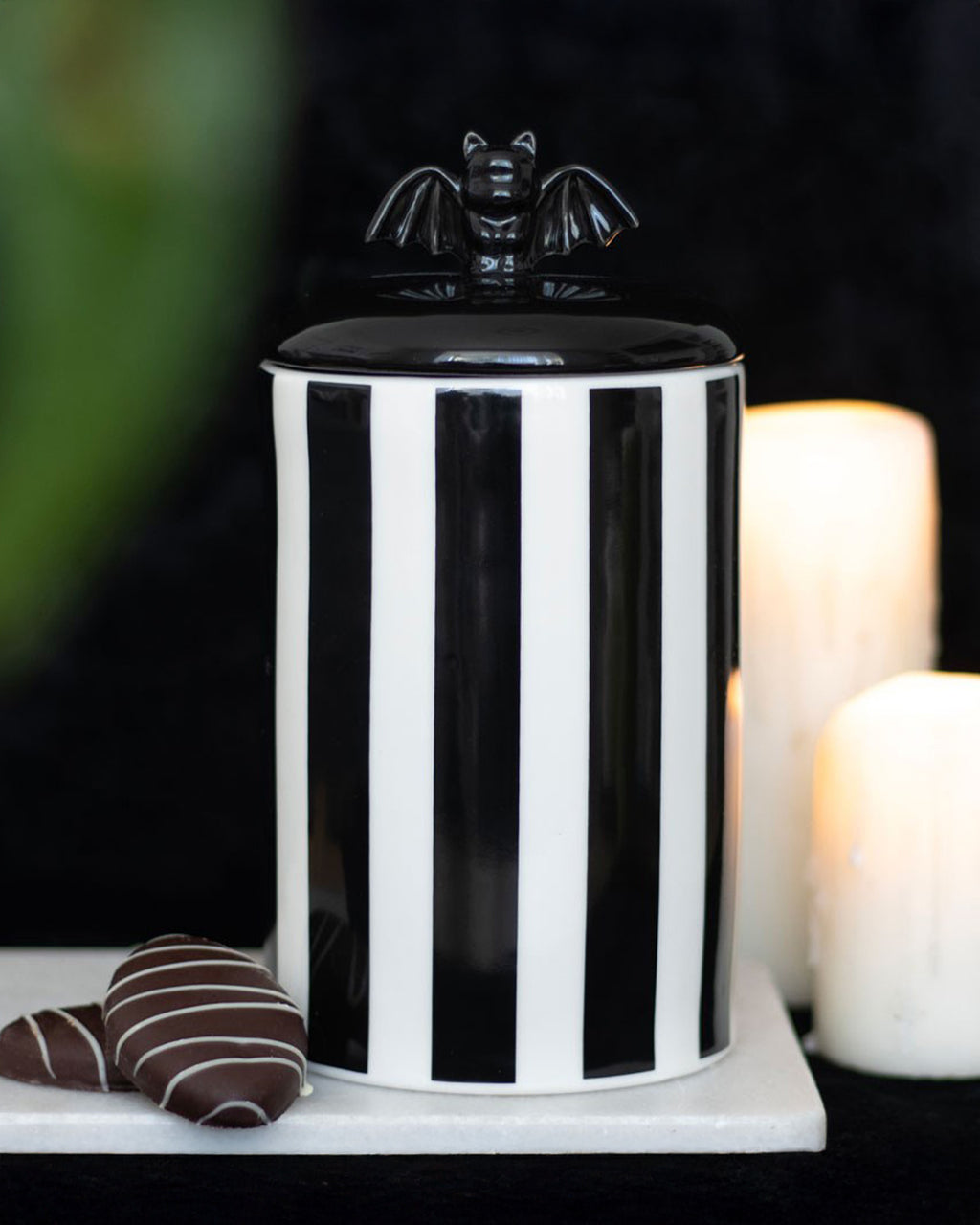 A moody, atmospheric shot of the Rebel Romance striped bat jar, styled with gothic elements like candles and chocolate treats. A must-have for dark and dramatic home aesthetics.