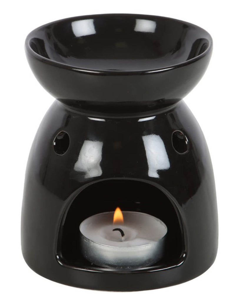 Back view of the oil burner showing the tealight holder with a lit candle inside, casting a soft glow.