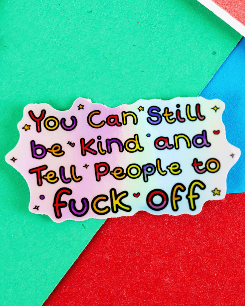 Holographic sticker on a colourful red, green and blue background, featuring bold rainbow text that reads “You Can Still be Kind and Tell People to fuck off.” The sticker has a wavy cut edge and playful fonts with sparkles and hearts. Sold by Rebel Romance, a UK brand that embraces alternative style and millennial-friendly designs.