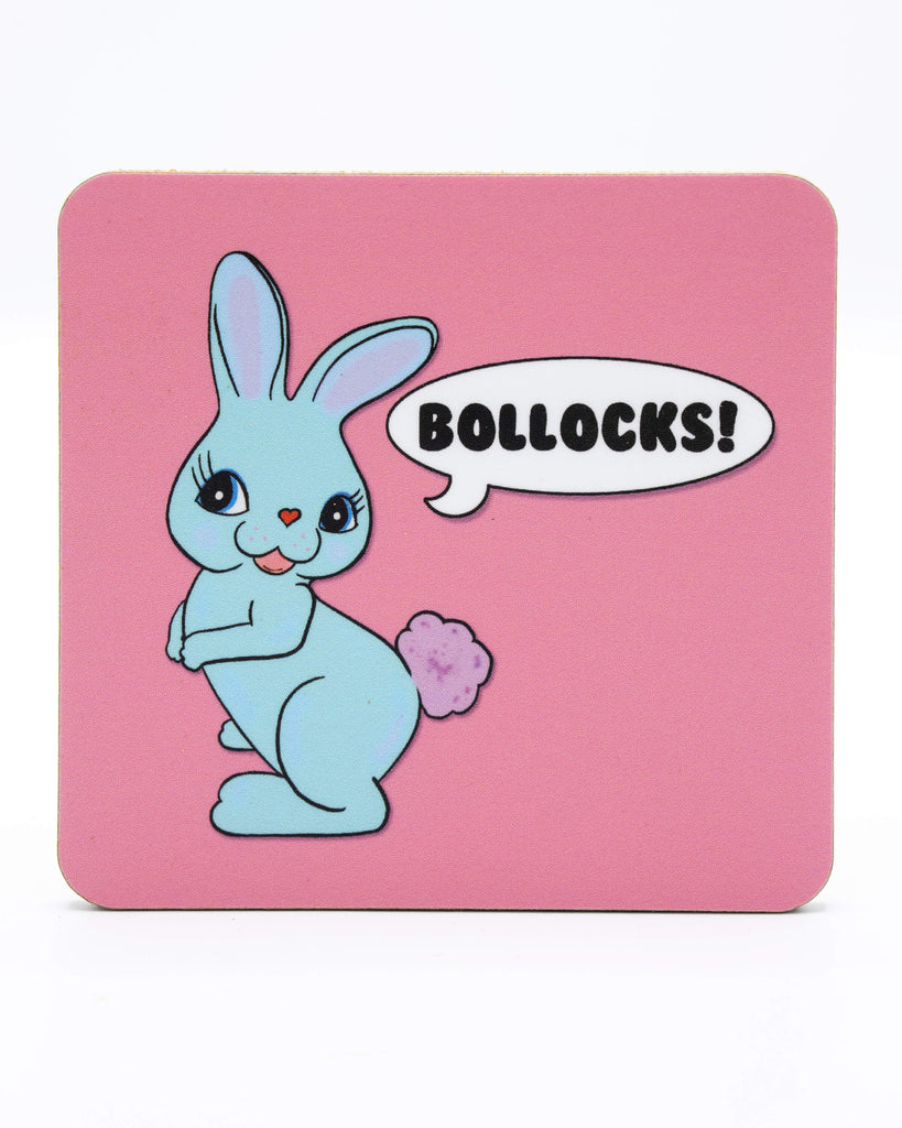 Pastel pink wooden coaster with a pastel blue kitsch rabbit with a speech bubble that reads 'Bollocks!'. A retro kitschy design from Bite Your Granny.