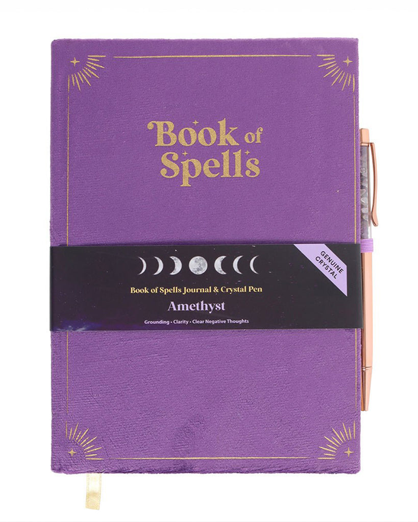 Book of Spells journal with its packaging. The black and purple sleeve highlights the amethyst crystal pen's properties—grounding, clarity, and clearing negative thoughts—alongside a moon phase design.