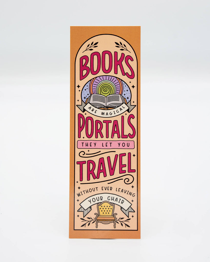 Peach and orange rectangular bookmark with bold pink and purple text reading "Books are magical portals – they let you travel without ever leaving your chair." Features whimsical illustration of an armchair, stars, and an open book. Designed by Rebel Romance, a UK brand known for alternative gifts, homeware, and millennial-friendly slow fashion.