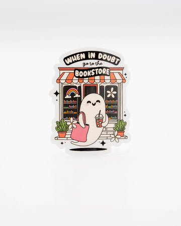 Cute vinyl die-cut sticker featuring a happy ghost holding iced coffee and a tote bag, standing outside a colourful bookshop. Text reads “When in doubt, go to the bookstore.” A playful bookish decal for readers and ghost lovers alike. Designed by Rebel Romance, a small UK brand known for celebrating alternative style, whimsical gifts, and millennial-friendly aesthetics.