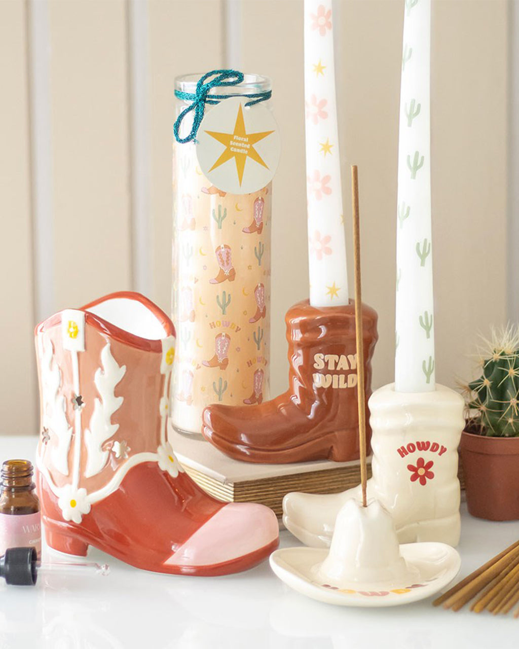 A western-inspired home decor display featuring a brown cowboy boot candle holder with 