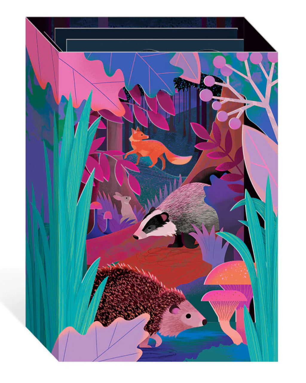 3D pop-up greeting card featuring a whimsical British woodland scene with a fox, hedgehog, badger, and mouse surrounded by vibrant foliage, mushrooms, and berries. Designed by Natasha Durley and sold by Rebel Romance, a UK small business celebrating extraordinary alternative style and gifts. The card unfolds to reveal layered wildlife artwork in rich pink, purple, and teal hues.