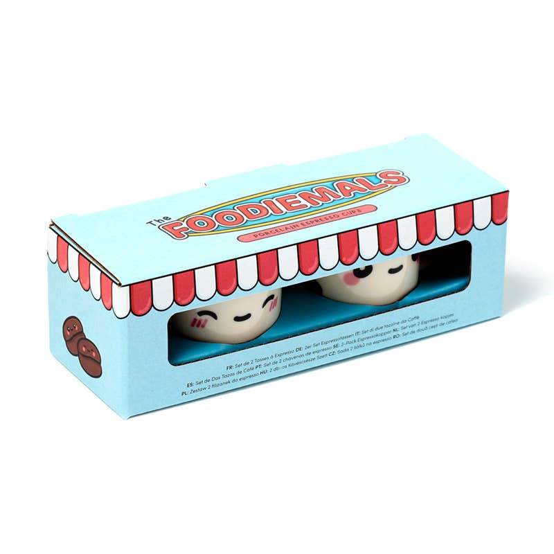 Gift box packaging for Rebel Romance’s Foodiemals espresso cup set. The box is sky blue with a red-and-white striped shop awning design and features two cartoon-style cups peeking through the window.