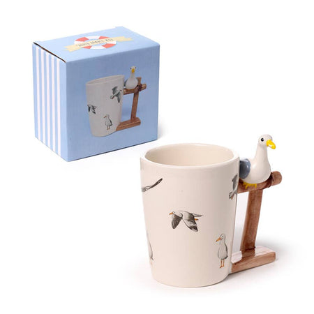 The full Seagull Buoy Mug set by Rebel Romance, showing the illustrated ceramic mug alongside its coordinating box. The shaped handle with perched seagull makes this a standout gift for fans of quirky, nautical mugs.