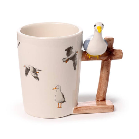 Front view of the Seagull Buoy Ceramic Shaped Handle Mug by Rebel Romance. Features a printed seagull design and a sculpted handle that looks like a dock post with a seagull sitting on top. A fun nautical-themed mug for tea or coffee.