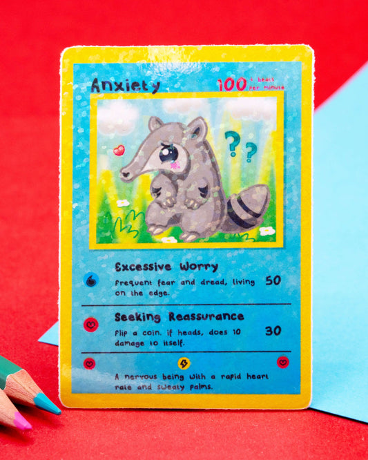 Anxiety collectable trading card sticker designed by Innabox, featuring a sparkly gloss finish and a cute nervous anteater character. The waterproof vinyl sticker includes humorous traits like “Excessive Worry” and “Seeking Reassurance”. A kawaii-style mental health support sticker perfect for decorating laptops, journals, or water bottles. 