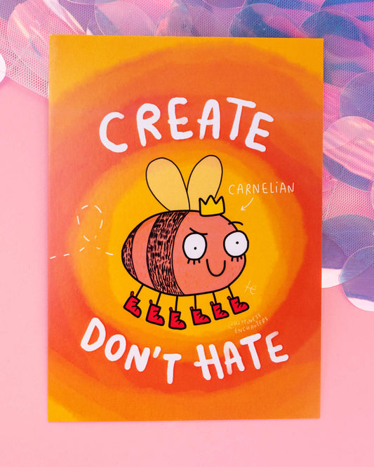 Bright orange and yellow postcard featuring a Carnelian crystal-inspired bee character in red boots and a crown, with the phrase "Create Don’t Hate" in bold white text. Illustrated by Katie Abey for Happiness Enchanters. Sold at Rebel Romance, a small UK business known for  alternative gifts, stationery and positive vibes.