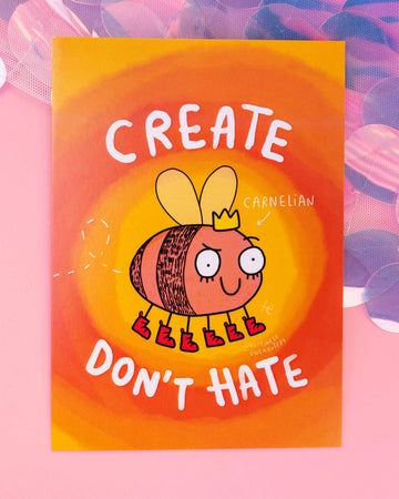 Bright orange and yellow postcard featuring a Carnelian crystal-inspired bee character in red boots and a crown, with the phrase "Create Don’t Hate" in bold white text. Illustrated by Katie Abey for Happiness Enchanters. Sold at Rebel Romance, a small UK business known for  alternative gifts, stationery and positive vibes.