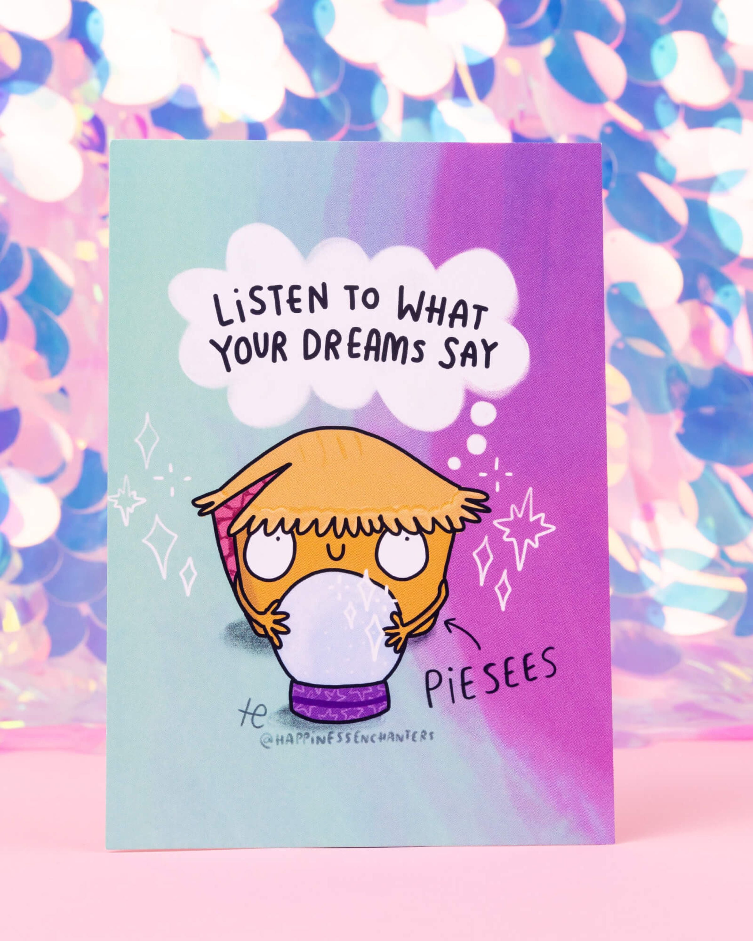 A colourful Pisces themed postcard featuring Piesees, a Katie Abey illustrated pie character holding a crystal ball with a dreamy expression. The text says 